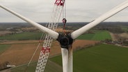 Eine verbrannte Windkraftanlage wird abgebaut. © Screenshot 