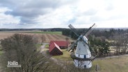 Neben einem Gutshof ist eine Windmühle zu sehen. © Screenshot 