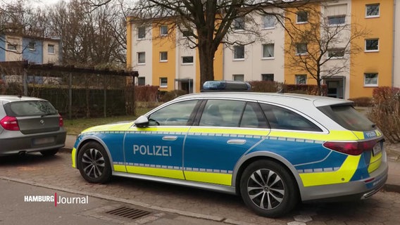 Ein Polizeiauto steht vor einem Häuserblock. © Screenshot 