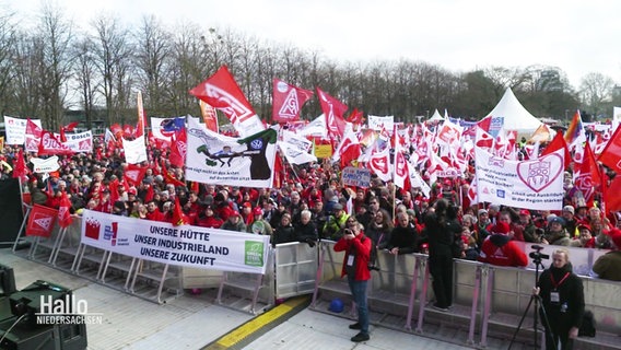 Menschen mit Flaggen der IG Metall auf einer Demo. © Screenshot 