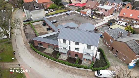 Blick aus der Vogelperspektive auf einen größeren Gebäudekomplex eines ehemaligen Supermarkts, der nun zu einem Wohnhaus umgebaut wurde. © Screenshot 