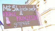 Ein Protest-Schild mit der Aufschrift: "Mit 5 habe ich auch Prinz und Prinzessin gespielt". © Screenshot 