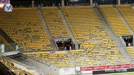 Zerstörte Sitzplätze auf einer Fußballtribüne. © Screenshot 