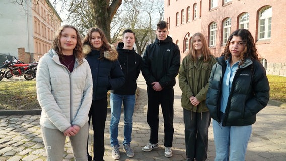 Schülerinnen und Schüler stehen auf einem Schulhof. © Screenshot 