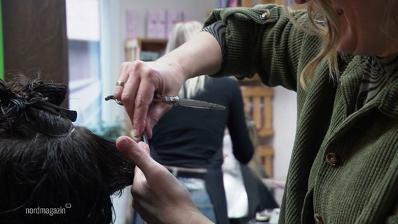 Eine Friseurin schneidet einer Kundin die Haare. © Screenshot 