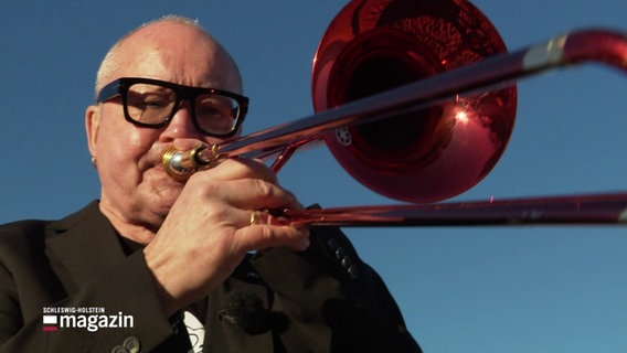 Jazzmusiker Nils Landgren spielt auf seiner roten Posaune. © Screenshot 