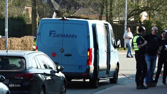 Polizeibeamte stehen neben einem Geldtransporter. © Screenshot 