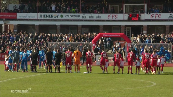 Die Mannschaften des FC Greifswald und Hansa Rostock stehen vor dem Anpfiff auf dem Platz. © Screenshot 