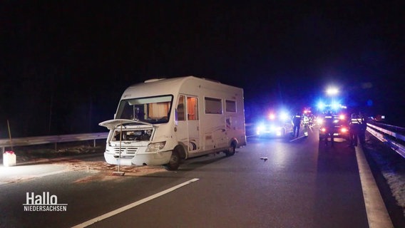 Ein nach einer Verfolgungsjagd gestopptes Wohnmobil steht mit geöffneter Motorhaube bei Nacht auf der Autobahn. © Screenshot 