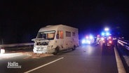 Ein nach einer Verfolgungsjagd gestopptes Wohnmobil steht mit geöffneter Motorhaube bei Nacht auf der Autobahn. © Screenshot 