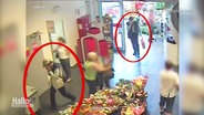 Aufnahmen einer Überwachungskamera zeigen zwei rot umkreiste Personen bei einem Überfall auf einen Supermarkt. © Screenshot 