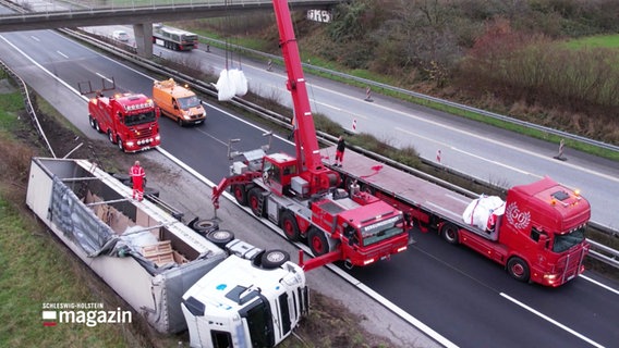 Ein umgekippter Lastwagen wird auf der Autobahn mit einem Kran geborgen. © Screenshot 