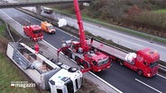 Ein umgekippter Lastwagen wird auf der Autobahn mit einem Kran geborgen. © Screenshot 