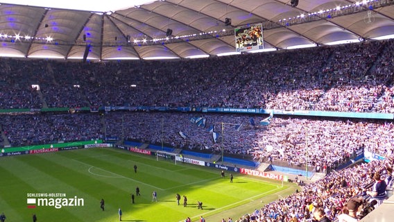 Das prall gefüllte Hamburger Volksparkstadion bei Sonnenschein. © Screenshot 