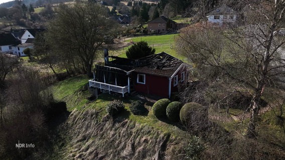 Ein abgebranntes Ferienhaus auf einer Klippe. © Screenshot 