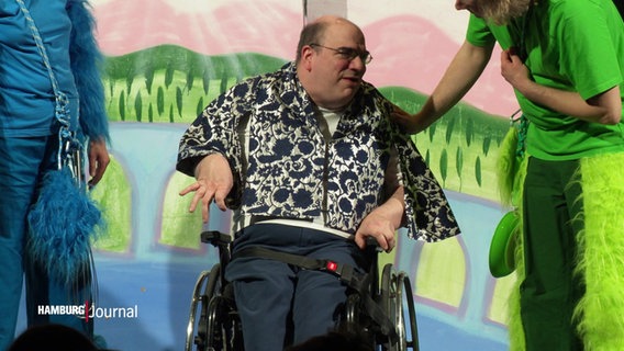 Schauspieler Lars Pietzko sitzt im Rollstuhl und tritt in der Rolle eines Zauberers auf der Bühne des Klabauter Theaters am Berliner Tor auf. © Screenshot 