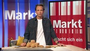 Jo Hiller modeeriert Markt. Vor ihm auf dem Studiotisch liegen Produkte aus Kork. © Screenshot 