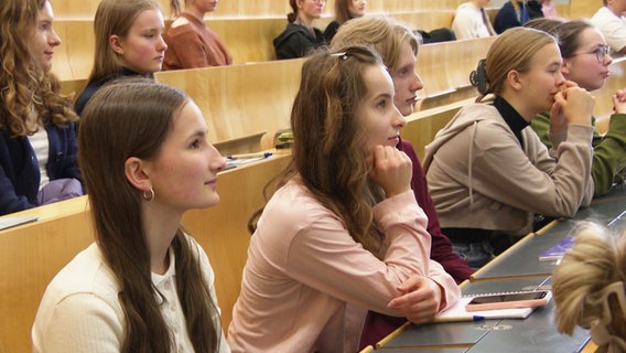 Mehrere junge Schülerinnen sitzen in einem Hörsaal. © Screenshot 