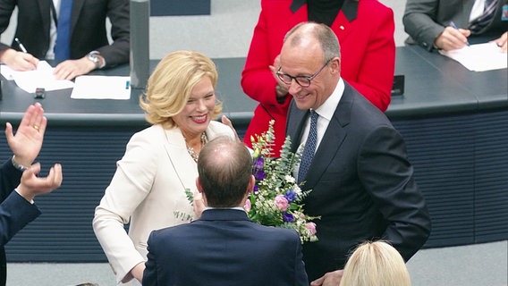 Julia Klöckner mit einem Blumenstrauß neben Friedrich Merz. © Screenshot 