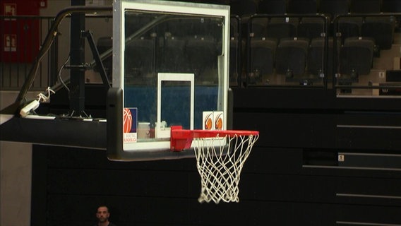 Ein Basketballkorb in einer Halle.  