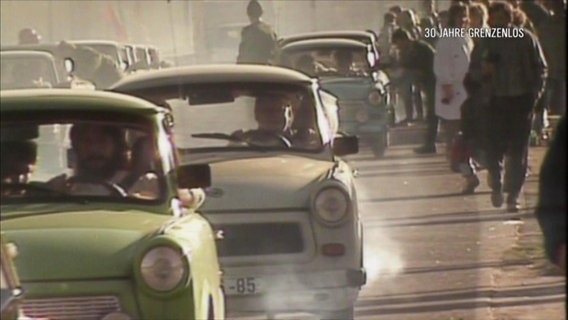 DDR-Bürger fahren nach dem Mauerfall mit ihren Trabbis in den Westen.  