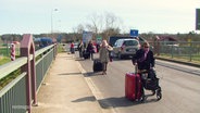 Touristen mit Rollkoffern auf der Strasse  