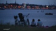 Ein Pärchen grillt am Wasser in Rostock 