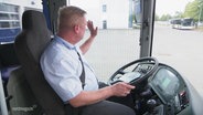 Busfahrer Heiko Müller winkt aus dem Fenster 