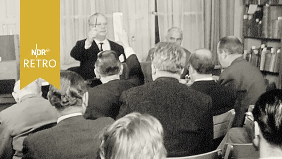 Auktionator und Teilnehmer bei einer Buchauktion 1960  