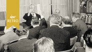Auktionator und Teilnehmer bei einer Buchauktion 1960  