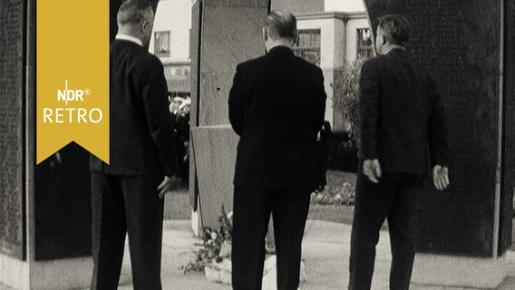 Drei ältere Herren bei der Kranzniederlegung am Gefallenendenkmal in Borkum 1965  
