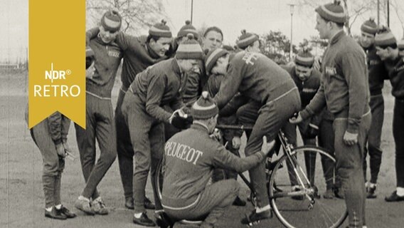 Wilhelm Thiele mit Nachwuchssportlern um ein Rennrad bei Erklärungen (1962)  