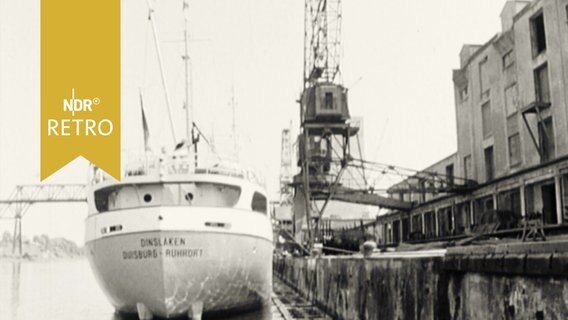 Schiff an einem Hafenkai (1963).  