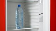 Eine Wasserflasche in einem ansonsten leeren Kühlschrank © CHROMORANGE Foto: R. Tscherwitschke