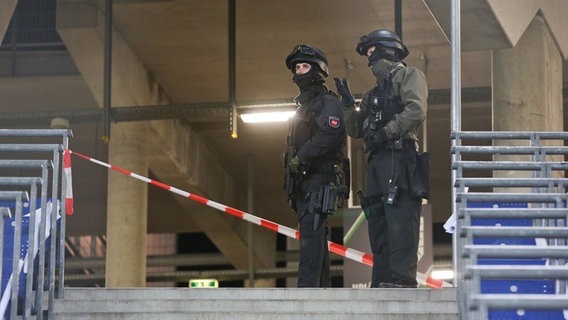 Spezialeinsatzkräfte stehen im sonst leeren Stadion. © dpa-Bildfunk Foto: Christian Charisius