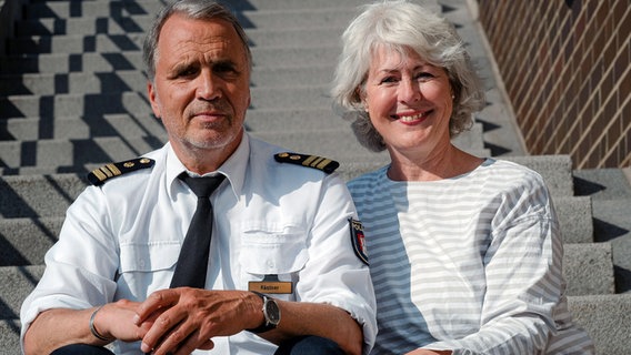 Angélique und Andreas Kästner sitzen auf einer Treppe und lächeln in die Kamera. © Kerstin Petermann 