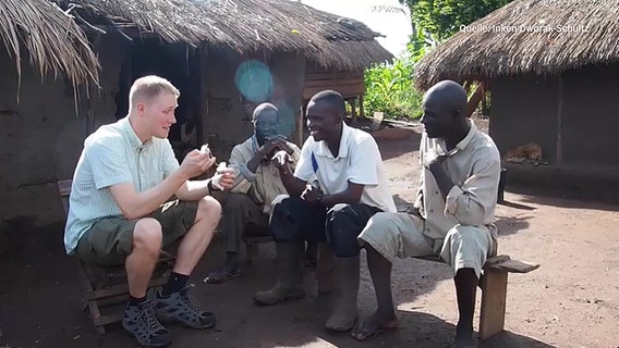 Ethnopharmakologe Fabien Schultz sitzt mit Einheimischen in Uganda © NDR.de 