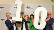 Die Ernährungs-Docs Matthias Riedl. Viola Andresen, Silja Schäfer und Jörn Klasen halten am 11.9.2024 im Liebermann-Studio in Hamburg Styropornummern in Form einer Zehn in die Luft. © NDR Foto: B. Probol