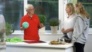 Dr. Klasen hält einen Handball, während er mit Mutter und Tochter spricht. © NDR/Moritz Schwarz 