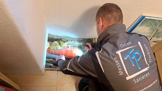Johannes Kadow sucht im Badezimmer seines Kunden nach einer Leckage. Das Messgerät zeigt ihm die Feuchtigkeit deutlich an. © NDR/UnderDok 