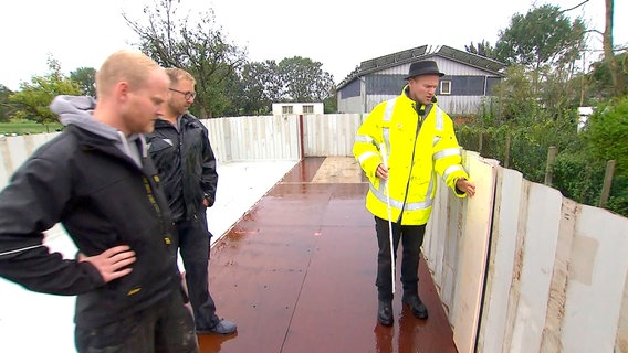 Jan-Peter Henningsen (rechts) will aus einem Hochseecontainer einen Swimming – Pool bauen. Unterstützt wird er dabei von Bruder Kay-Uwe (links) und Freund Finn Matthiesen. © NDR/Produktion Clipart 