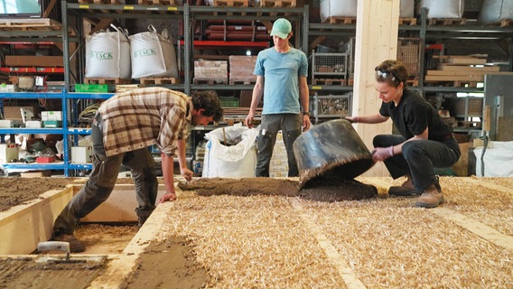 Als erste Putzschicht kommt Lehm drauf - schon in der Vorproduktion in der Halle. © NDR/AP: Hanse TV 