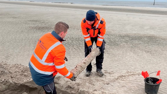 Munitionssucher Patrick und André Warfsmann bergen eine angespülte Granate am Strand von Wangerooge. © NDR/Bärbel Fening 