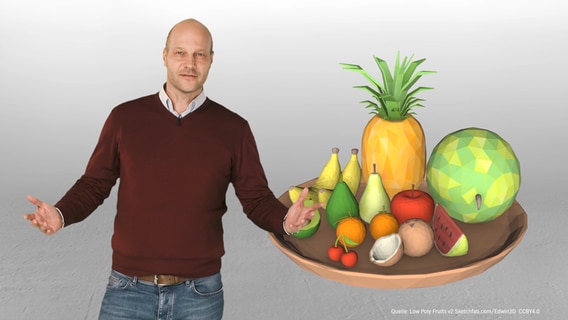 Philipp Abresch steht neben einen Obstschale.  