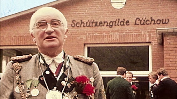 Älterer Mann mit Brille und Paradeuniform vor dem Schützenhaus in Lüchow. Aufnahme von 1977. © NDR 