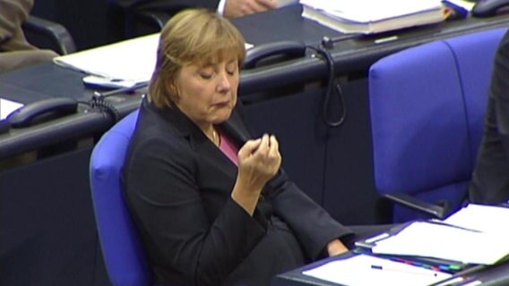 Angela Merkel guckt sich im Bundestag gelangweilt auf die Fingernägel. © NDR 