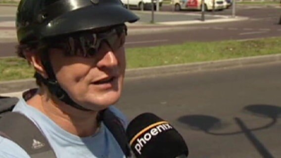 Ein Mann mit Motorradhelm spricht in ein Phoenix-Mikrofon. © Phoenix Foto: Screenshot