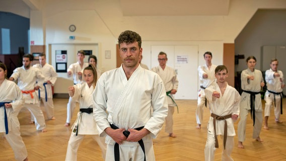 Nils Sanchez (Enrique Fiß, l.) unterrichtet nebenbei Kinder und Jugendliche in Taekwondo (mit Niklas Post, 3.v.r. und KomparsInnen) . © ARD/Thorsten Jander, 