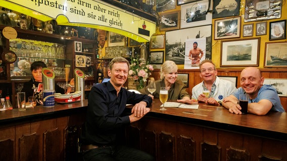 Michael Kessler, Ina Müller, Wigald Boning und Bernhard Hoëcker sitzen bei Inas Nacht zusammen am Tresen. © NDR/ Morris Mac Matzen Foto: Morris Mac Matzen