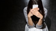 Junge Frau mit Smartphone senkt ihren Kopf in die Hände. © Fotolia.com Foto: kei907